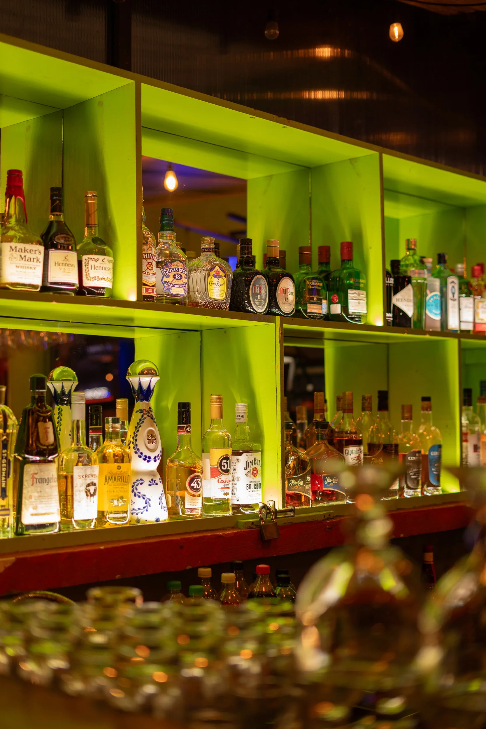 Botellas en el bar con iluminación verde neón