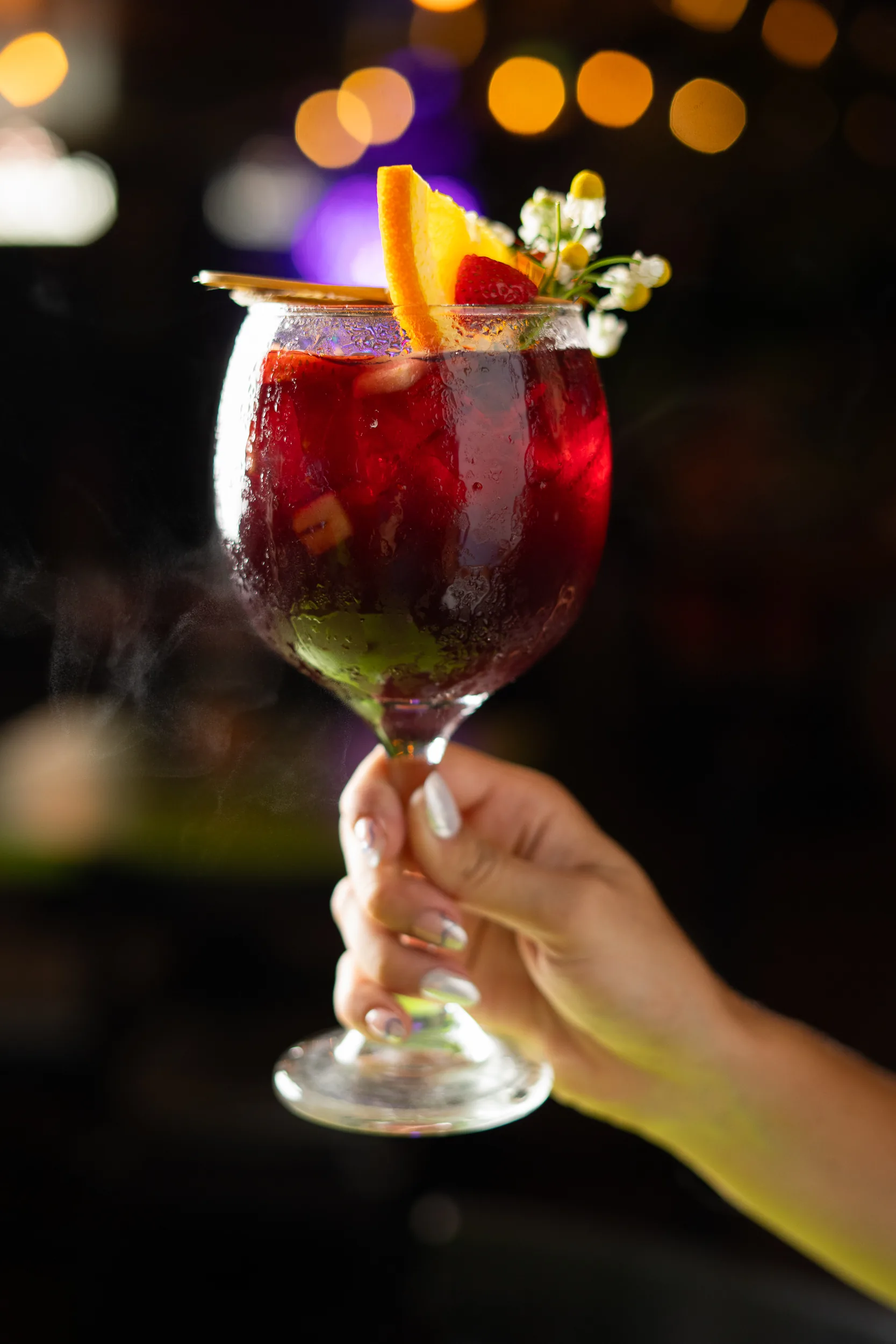 Sangría de la casa — cóctel con frutas y bokeh de luces